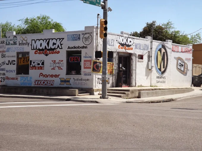 MoKick Car Audio's storefront at 101 E Saunders St, Laredo: a white building painted with car audio brand logos and the MOKICK CarAudio sign